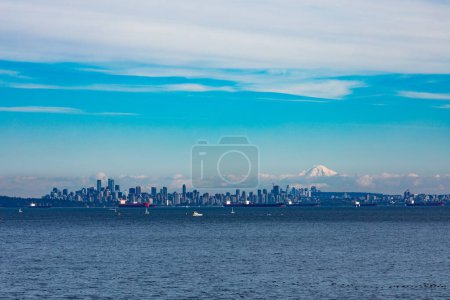 Photo for Vancouver City at the Western Canadian Pacific Ocean coast with oil tankers anchored in harbor and Mount Baker in the far distance shadowing the cityscape skyline, Biritish Columbia, BC, Canada - Royalty Free Image