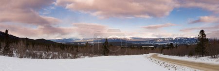 Sunset clouds over Road in winter landscape panorama outside wilderness city of Whitehorse, Yukon Territory, Canada