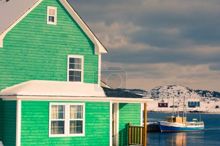 Photo for Traditional green wooden house at Durrell Harbour of outport fishing town of Twillingate at wintertime, Newfoundland, NL, Canada - Royalty Free Image