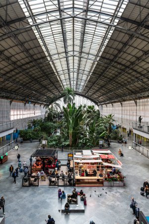 Photo for MADRID, SPAIN - MARCH 23, 2023: Travellers inside the tropical garden in Atocha's train station, Madrid, Spain. - Royalty Free Image