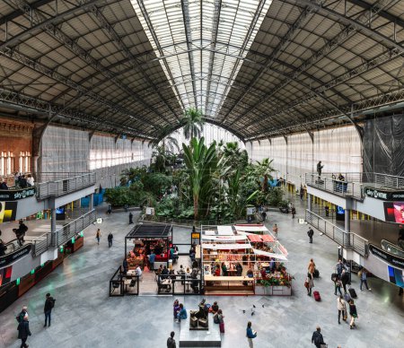 MADRID, SPAIN - MARCH 23, 2023: Travellers inside the tropical garden in Atocha's train station, Madrid, Spain.