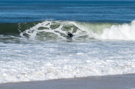 Photo for Bodyboarder surfing ocean wave on a sunny winter day. - Royalty Free Image