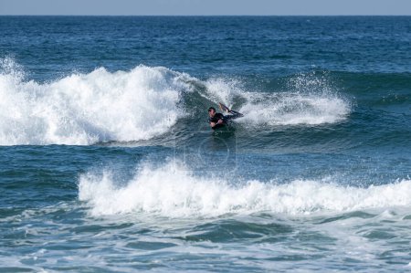 Photo for Bodyboarder surfing ocean wave on a sunny winter day. - Royalty Free Image