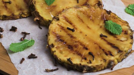 Photo for Grilled pineapple slices on wooden table. - Royalty Free Image