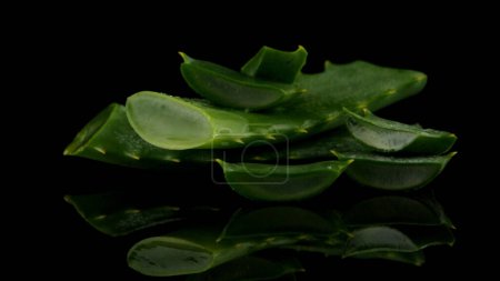 Photo for Sliced aloe leaf and water drops isolated on black background. - Royalty Free Image