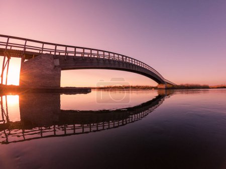 Photo for Wooden bridge over the water. Autumn sunset light light in Esmoriz, Ovar - Portugal. - Royalty Free Image