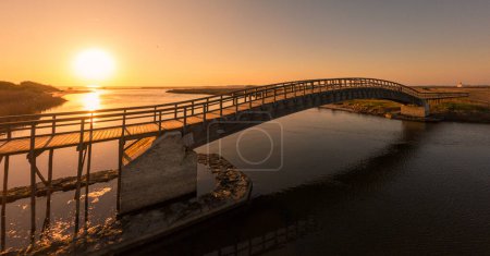 Puente de madera sobre el agua. Luz de puesta de sol de otoño en Esmoriz, Ovar - Portugal
.