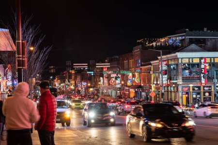 Foto de Nashville, Tennesee - January 21, 2023:  Street scene from famous lower Broadway in Nashville Tennessee viewed at night with lights, historic honky-tonks, bars and restaurants. - Imagen libre de derechos