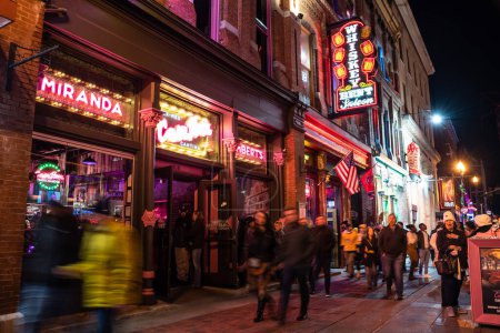 Foto de Nashville, Tennesee - January 21, 2023:  Street scene from famous lower Broadway in Nashville Tennessee viewed at night with lights, historic honky-tonks, bars and restaurants. - Imagen libre de derechos