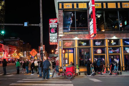 Photo for Nashville, Tennesee - January 21, 2023:  Street scene from famous lower Broadway in Nashville Tennessee viewed at night with lights, historic honky-tonks, bars and restaurants. - Royalty Free Image