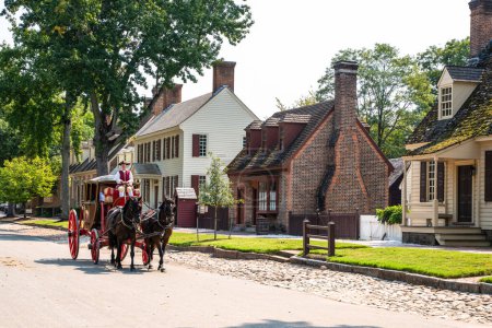 Photo for Williamsburg, Virginia, USA - September 12, 2021:  Street scene with horse drawn carriage along the street in historic Colonial Williamsburg VA. - Royalty Free Image