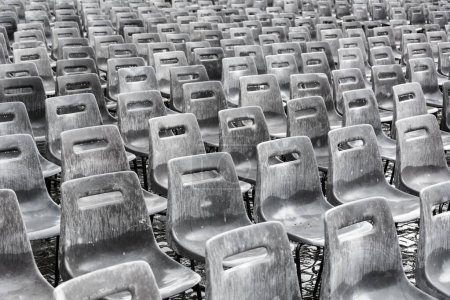 Téléchargez les photos : Rangées de chaises grises vides sous la pluie, fond
. - en image libre de droit