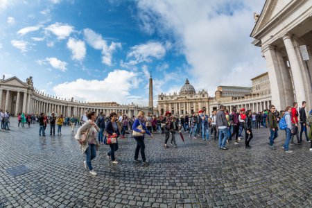 Foto de Vatican - Oct 06, 2018: Tourists bustle around St. Peter s Square in front of St Peters Cathedral - Imagen libre de derechos