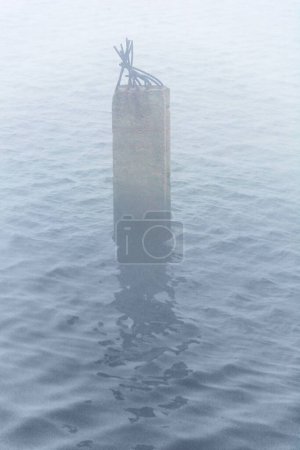 Téléchargez les photos : Un pittoresque pilier de béton sort de l'eau - en image libre de droit