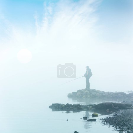 Téléchargez les photos : Unidentifiable fisherman silhouette in heavy fog - en image libre de droit