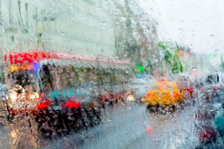 Téléchargez les photos : Mauvais temps, pluie, circulation dans la rue photographiée à travers du verre mouillé. - en image libre de droit