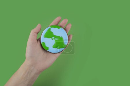 Earth Day concept. Cookie in shape of Earth in hand. Mouse Pad 707726836
