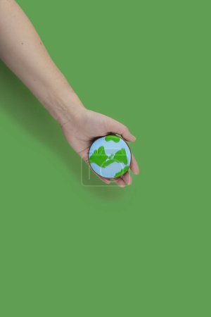 Earth Day concept. Cookie in shape of Earth in hand. Stickers 707726840