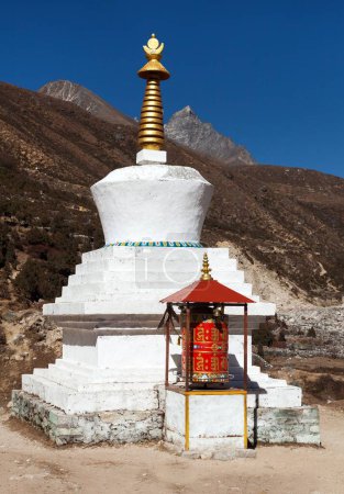 Photo for Buddhist stupa and prayer wheel in Thame village, Khumbu valley on three passes trek, Mount Everest area, Sagarmatha national park, Nepal - Royalty Free Image