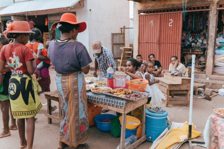 Foto de Miandrivazo, Madagascar - November 1. 2022: Street food seller on the main street in Miandrivazo. In Madagascar, people usually eat on the street. - Imagen libre de derechos