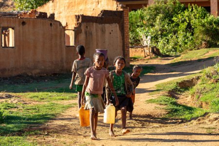Téléchargez les photos : Lakanga, montagne Andringitra, Madagascar - 15 novembre 2022 :, Madagascar - 15 novembre 2022 : Des filles malgaches du village de Lakanga livrent de l'eau pour cuisiner le matin. - en image libre de droit