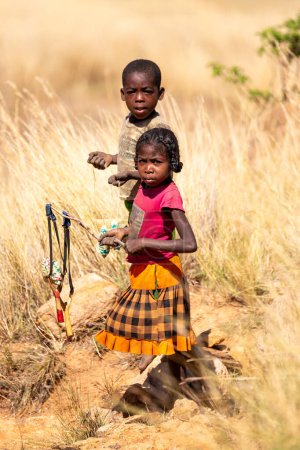 Téléchargez les photos : Montagnes Andringitra, Madagascar - 15 novembre 2022 : Jeune fille et garçon locaux vendant des souvenirs debout dans un paysage montagneux. Andringitra, Madagascar - en image libre de droit