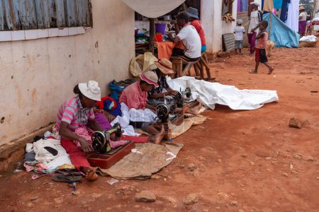 Téléchargez les photos : Mandoto, Madagascar - November 9. 2022: Street tailors, seamstress work with their outdated manual sewing machines. Earn some money in Madagascar is very difficult. - en image libre de droit