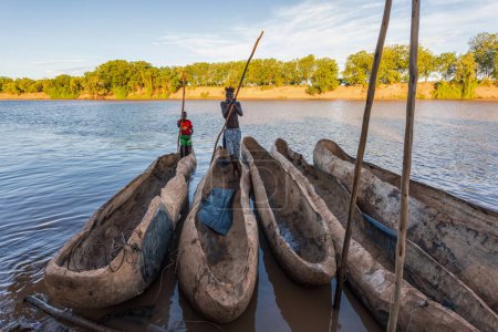 Foto de Valle de Omo, Etiopía - 11 de mayo de 2019: Captura del barquero maniobrando un barco tradicional de madera a lo largo del río Omo, ofreciendo un vistazo a la cultura ribereña local. - Imagen libre de derechos