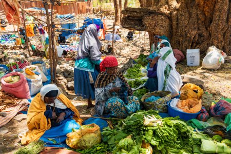 Foto de DEBRE LIBANOS, ETIOPÍA - 19 DE ABRIL DE 2019: Mujer etíope no identificada vende frutas y verduras en un mercado callejero, la Catedral de Debre Libanos, el 19 de abril. 2019 en Debre Libanos, Región de Oromia Etiopía - Imagen libre de derechos