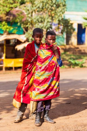 Téléchargez les photos : DEMEBECHA, ETHIOPIE, 20 AVRIL 2019. Rue éthiopienne le matin, les adolescents locaux couverts d'une couverture pour éviter le froid. Demebecha, région d'Amhara Éthiopie, 20 avril. 2019 - en image libre de droit