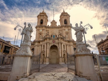 Majestuosa iglesia parroquial de Zabbar en Malta, un símbolo de fe y herencia, de pie contra el cielo al atardecer.