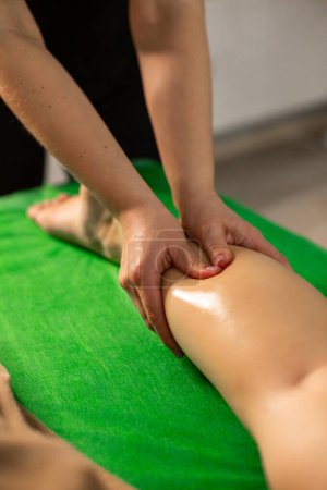 Téléchargez les photos : Gros plan des mains du masseur faisant un massage à la jambe d'une femme pendant la procédure de spa - en image libre de droit
