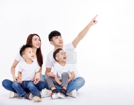 Foto de Happy Asian family  sitting on white floor and looking up - Imagen libre de derechos