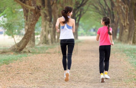 Foto de Rear view Mother and daughter jogging in the park - Imagen libre de derechos