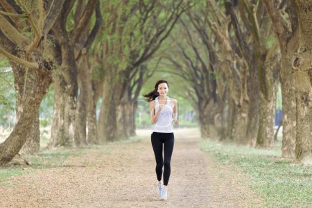 Téléchargez les photos : Healthy young woman running in the park at morning - en image libre de droit