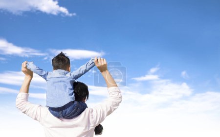 Téléchargez les photos : Father giving son piggyback ride on his shoulders and looking the cloud - en image libre de droit
