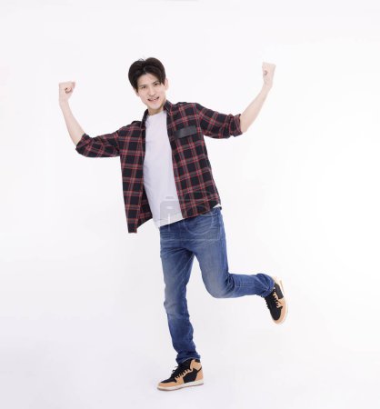 Photo for Excited young man dancing and jumping  with success gesture - Royalty Free Image