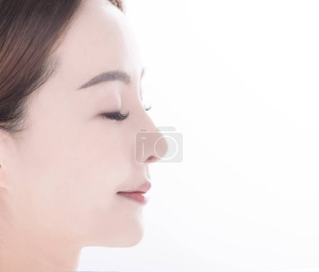 Téléchargez les photos : Vue latérale de la jeune femme asiatique avec une peau propre et fraîche sur fond blanc - en image libre de droit