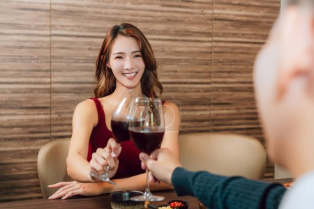 Téléchargez les photos : Young happy couple celebrating and toasting with wine glasses in  restaurant. - en image libre de droit