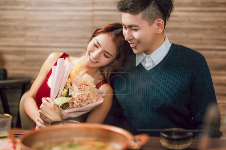 Téléchargez les photos : Jeune homme saluant sa petite amie le jour de la Saint-Valentin au restaurant - en image libre de droit