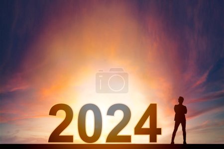Téléchargez les photos : Homme d'affaires stand avec 2024 nouveau concept de l'année et le lever du soleil arrière-plan - en image libre de droit