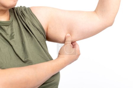 Foto de Mujer revisando la parte superior del brazo y exceso de grasa - Imagen libre de derechos