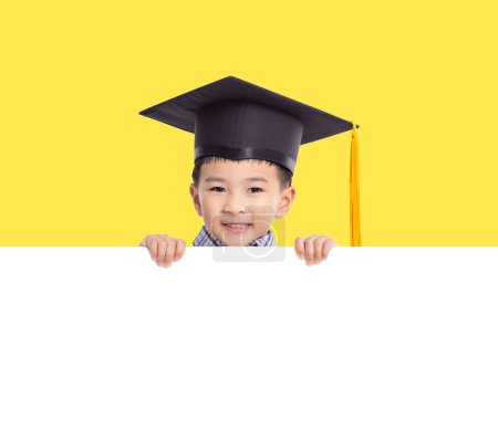 Foto de Niño feliz en gorra de graduación y sosteniendo con bandera blanca vacía - Imagen libre de derechos