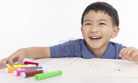 Photo for Smiling asian child schoolboy painting and drawing at home - Royalty Free Image