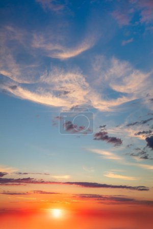Téléchargez les photos : Ciel réel - Fond de nuages de cirrus de lumière dans le ciel bleu pendant le coucher du soleil de l'aube avec un vrai soleil. Sans oiseaux. Vertyque. Contexte naturel - en image libre de droit