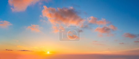Foto de Paisaje nublado de pastel. Salida del sol cielo al atardecer con nubes de colores claros sin aves. Con sol. Foto panorámica de gran tamaño - Imagen libre de derechos