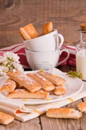 Téléchargez les photos : Biscuits feuilletés avec sucre glace sur un plat blanc. - en image libre de droit
