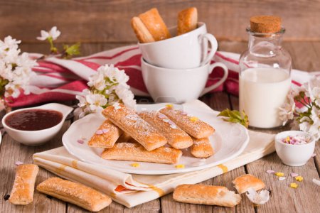 Téléchargez les photos : Biscuits feuilletés avec sucre glace sur un plat blanc.. - en image libre de droit
