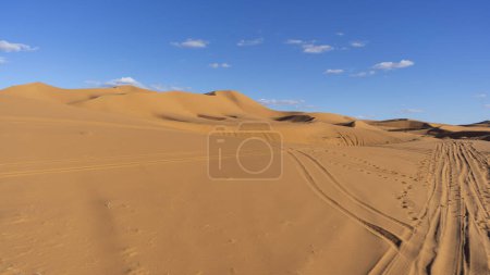 Foto de Luz del atardecer y huellas en el desierto de Merzouga en Marruecos - Imagen libre de derechos