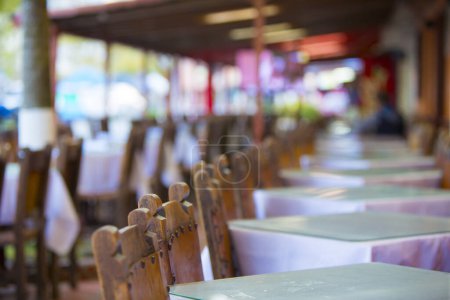 Foto de Restaurante en Guatape con sillas y mesas de madera antiguas en una fila - Imagen libre de derechos